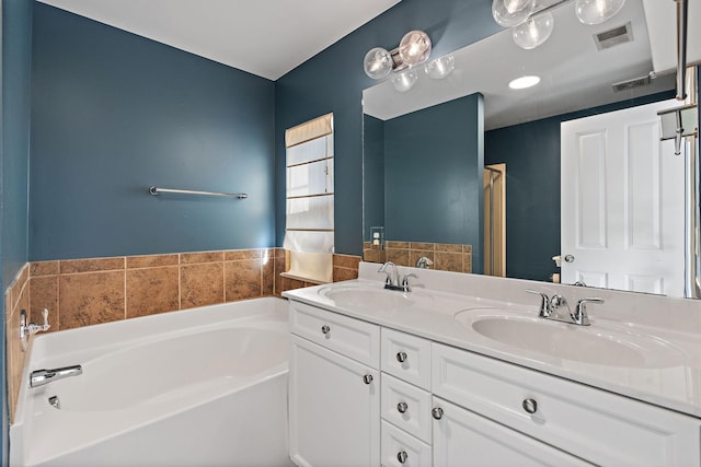 bathroom featuring a garden tub, a sink, visible vents, and double vanity