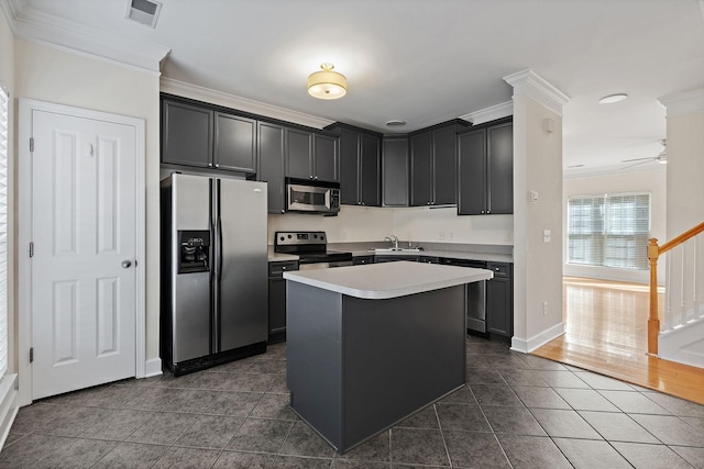 kitchen featuring visible vents, appliances with stainless steel finishes, ornamental molding, dark tile patterned floors, and a sink