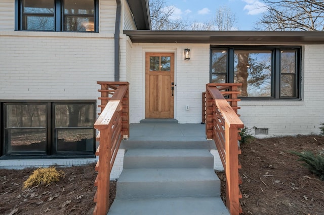 entrance to property with crawl space and brick siding