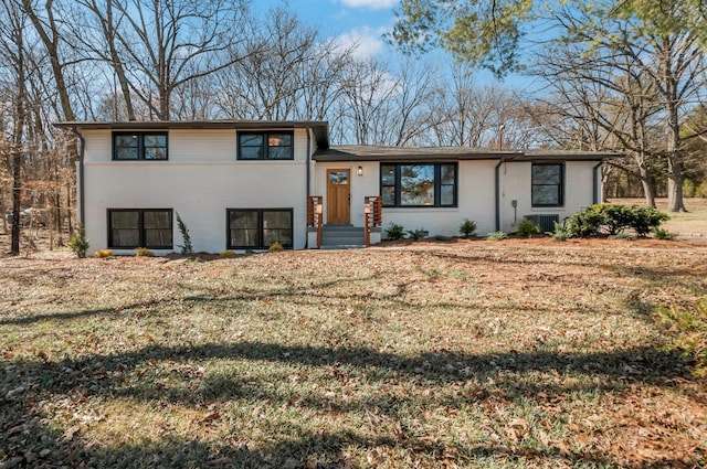 tri-level home featuring a front lawn and brick siding