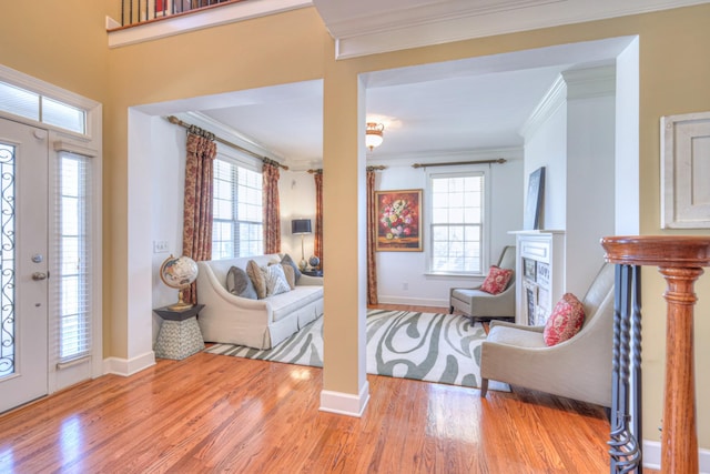 foyer featuring baseboards, crown molding, and wood finished floors