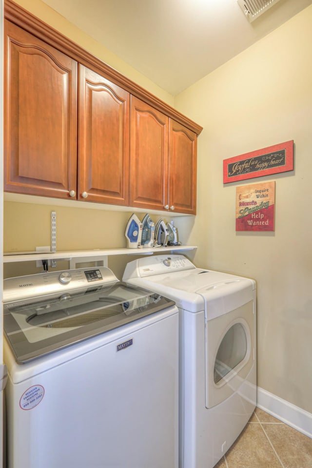 washroom with cabinet space, light tile patterned floors, baseboards, and separate washer and dryer