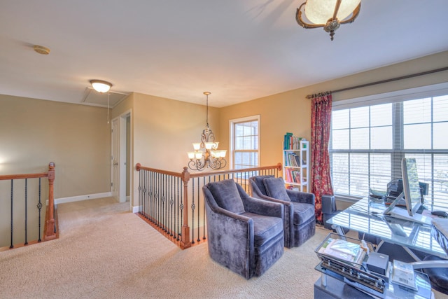 living room with attic access, carpet flooring, a notable chandelier, and baseboards