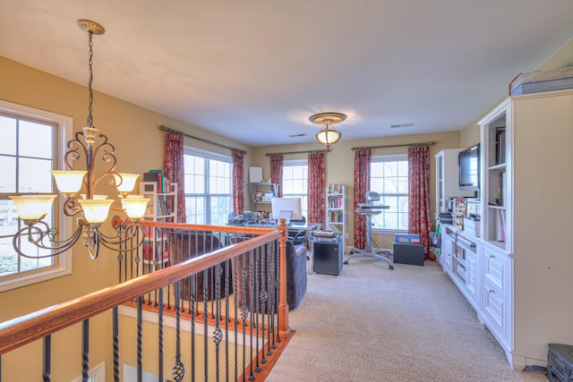 corridor featuring light carpet, a notable chandelier, and an upstairs landing