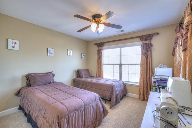 bedroom with light carpet, ceiling fan, visible vents, and baseboards