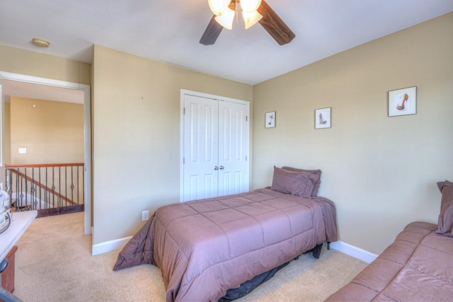 carpeted bedroom featuring a ceiling fan, baseboards, and a closet