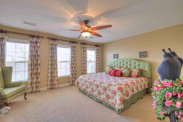 carpeted bedroom with a ceiling fan, visible vents, and baseboards