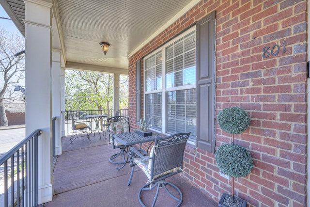 view of patio with a porch and outdoor dining area