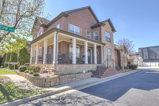 traditional-style home featuring covered porch and brick siding