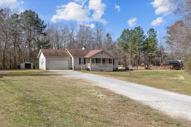 view of front of house featuring covered porch, a front yard, fence, a garage, and driveway