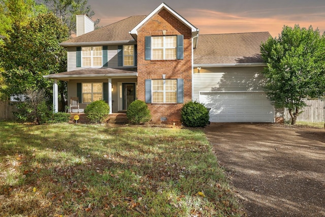 view of front of property with brick siding, a chimney, fence, a garage, and driveway