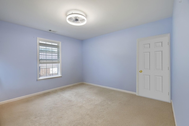 carpeted spare room with baseboards and visible vents