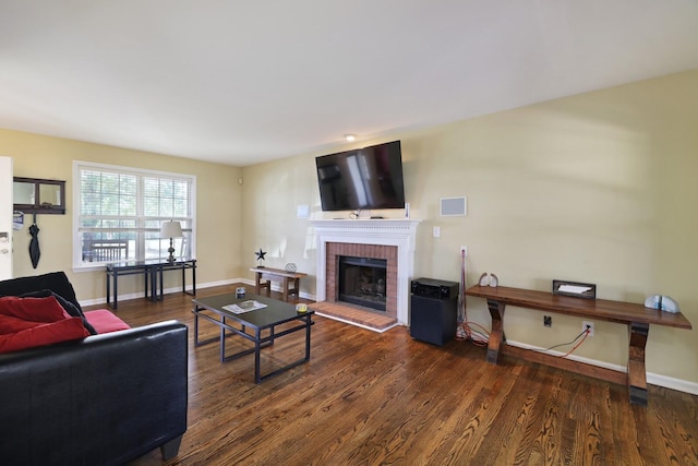 living area with a fireplace, wood finished floors, and baseboards