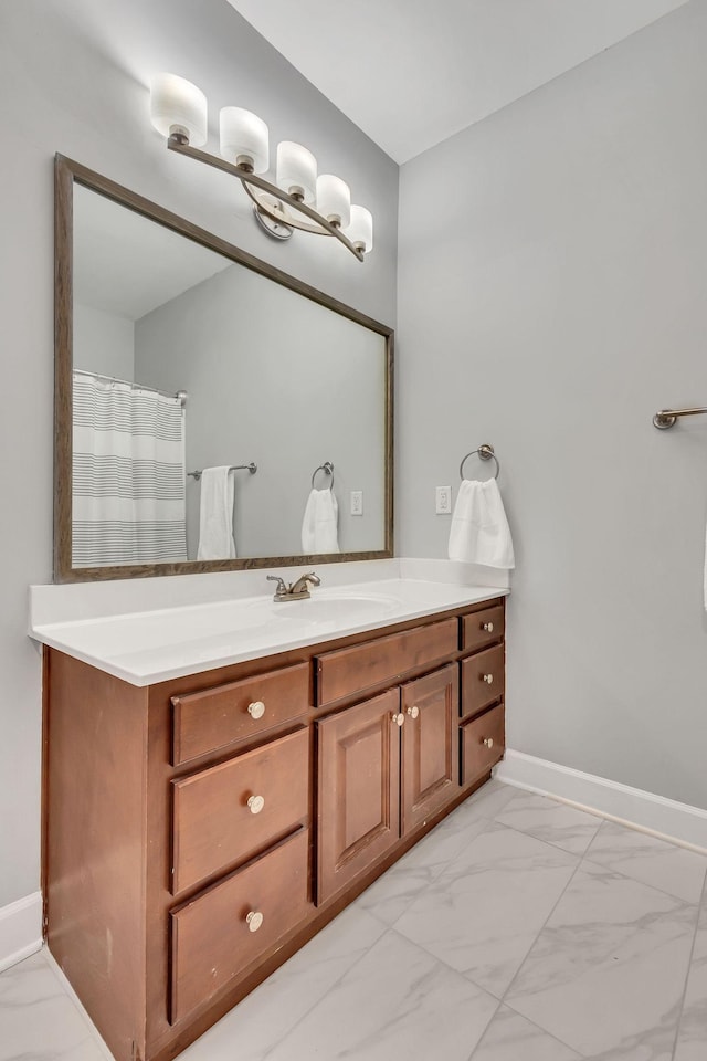 bathroom featuring marble finish floor, baseboards, and vanity