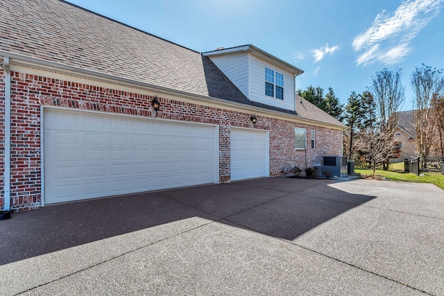 view of home's exterior with driveway, roof with shingles, a garage, and brick siding