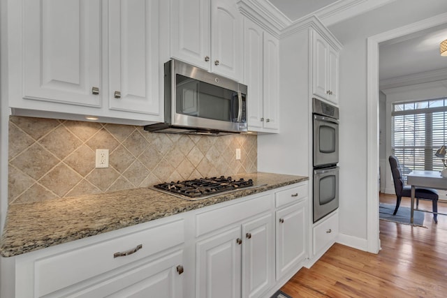 kitchen featuring light wood-style flooring, appliances with stainless steel finishes, light stone counters, crown molding, and white cabinetry