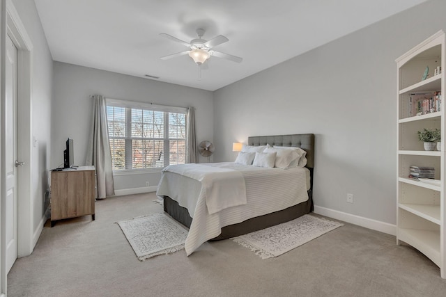 bedroom with baseboards, ceiling fan, visible vents, and light colored carpet