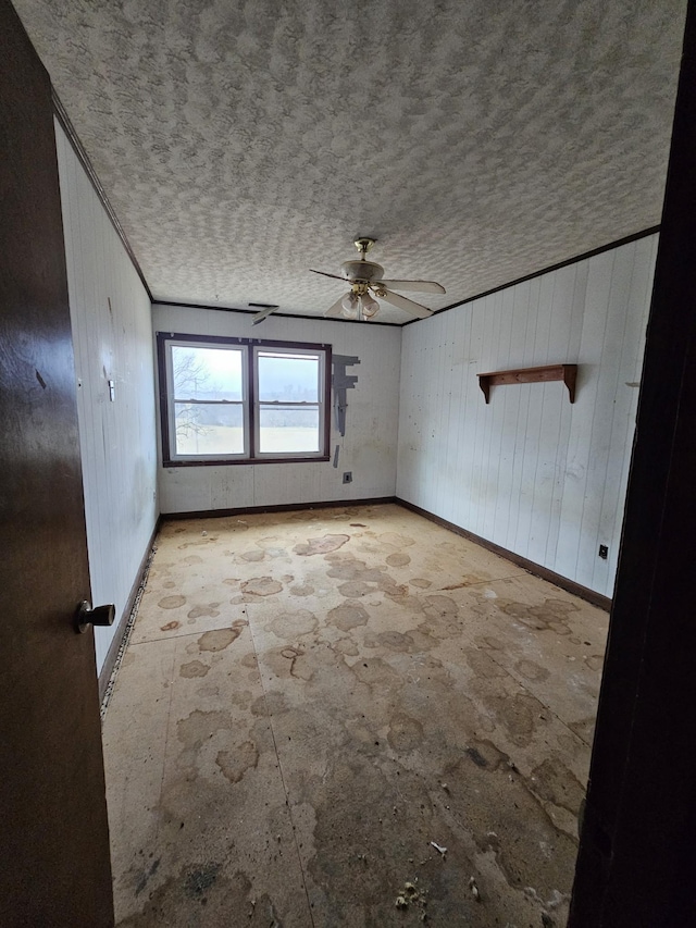 unfurnished room with a ceiling fan, a textured ceiling, and baseboards