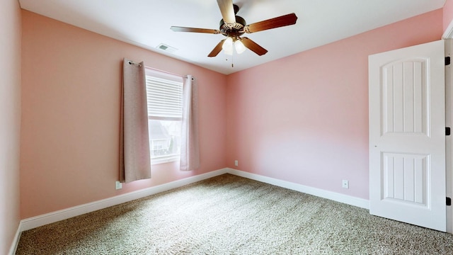 empty room featuring carpet, visible vents, baseboards, and ceiling fan