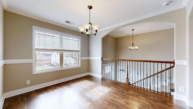 unfurnished room featuring a chandelier, visible vents, crown molding, and wood finished floors