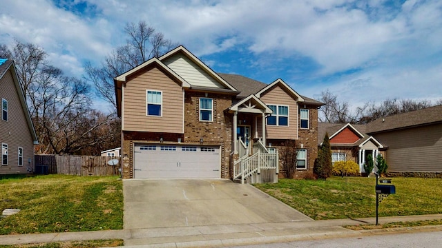 bi-level home featuring an attached garage, brick siding, fence, driveway, and a front yard