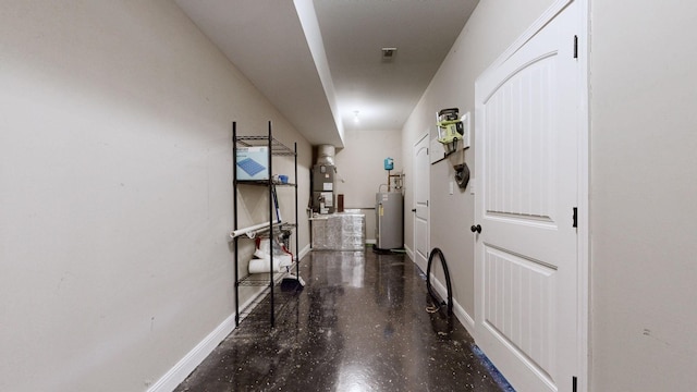 hall with water heater, baseboards, and finished concrete floors