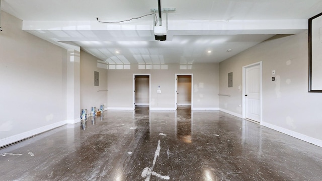 garage featuring a garage door opener, electric panel, and baseboards