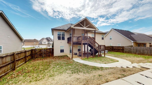 rear view of property with a residential view, a fenced backyard, a yard, and stairs