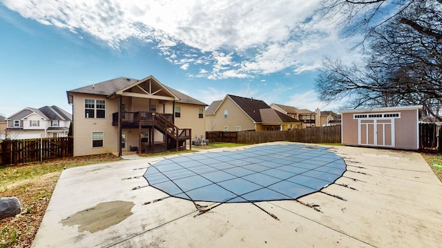 view of swimming pool featuring a storage shed, a patio area, an outdoor structure, and a fenced backyard