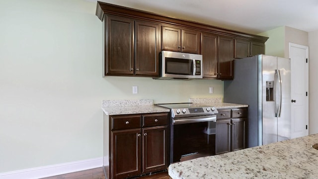 kitchen with baseboards, appliances with stainless steel finishes, dark wood-style flooring, and dark brown cabinets