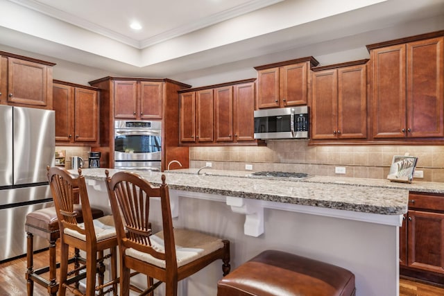 kitchen with tasteful backsplash, appliances with stainless steel finishes, dark wood finished floors, and ornamental molding