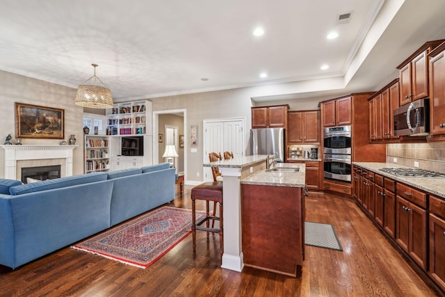 kitchen with visible vents, dark wood finished floors, a breakfast bar area, open floor plan, and stainless steel appliances