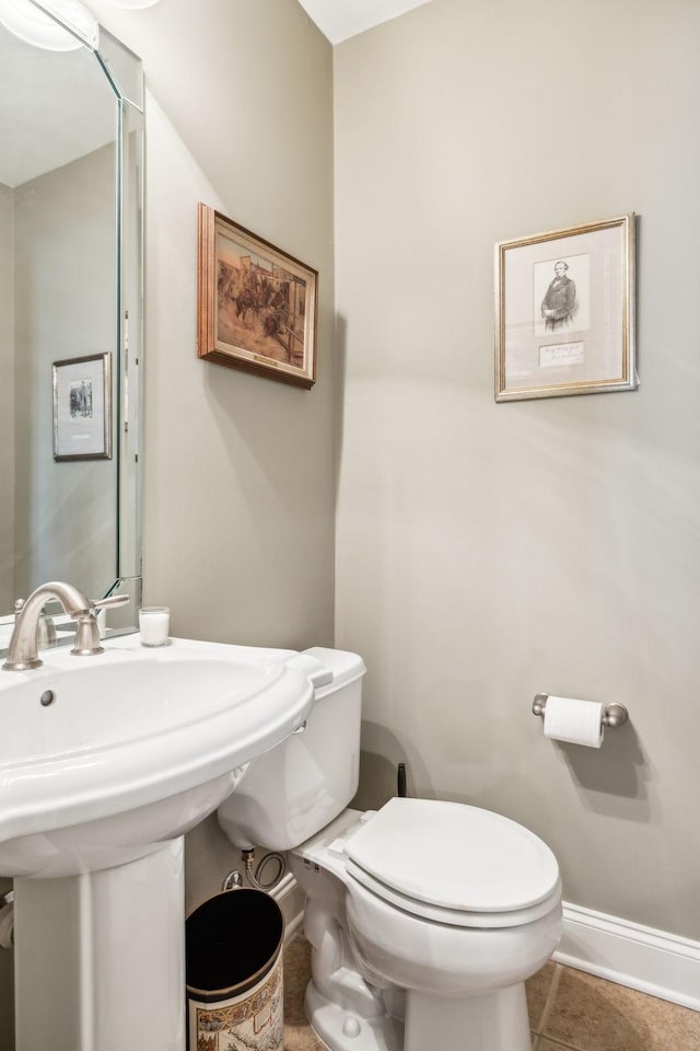 bathroom featuring tile patterned flooring, toilet, and baseboards