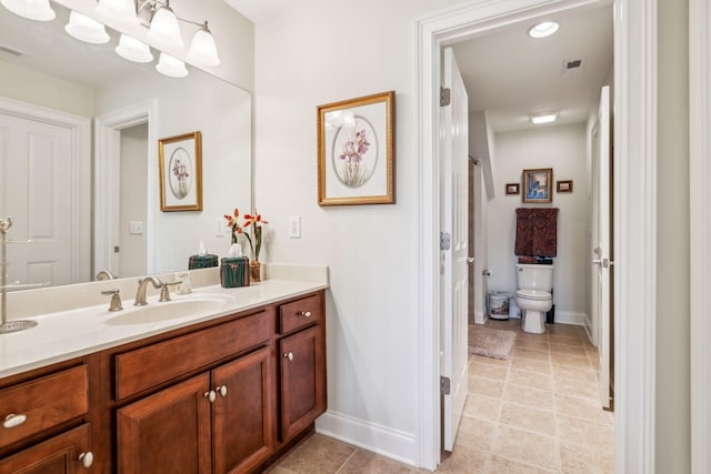 bathroom featuring toilet, baseboards, visible vents, and vanity