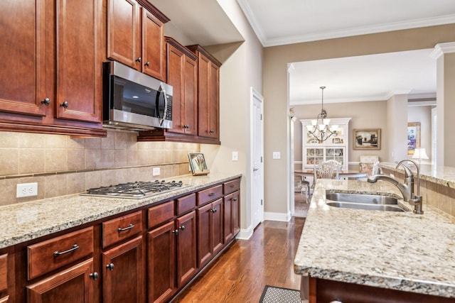 kitchen with decorative backsplash, dark wood-style floors, ornamental molding, stainless steel appliances, and a sink