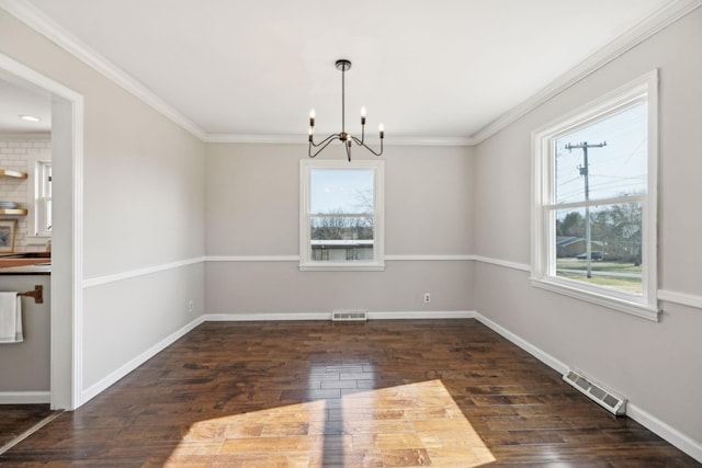 unfurnished dining area with visible vents, baseboards, an inviting chandelier, and wood finished floors