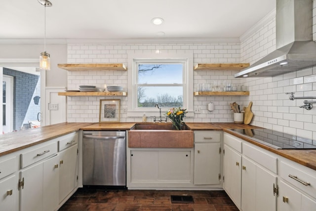 kitchen with butcher block countertops, open shelves, stainless steel dishwasher, wall chimney range hood, and black electric cooktop