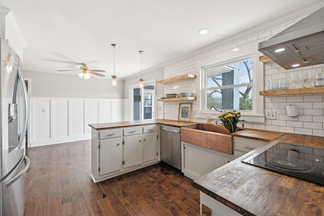 kitchen with plenty of natural light, stainless steel appliances, wood counters, and open shelves