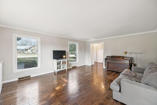 living room with visible vents, crown molding, baseboards, and wood finished floors