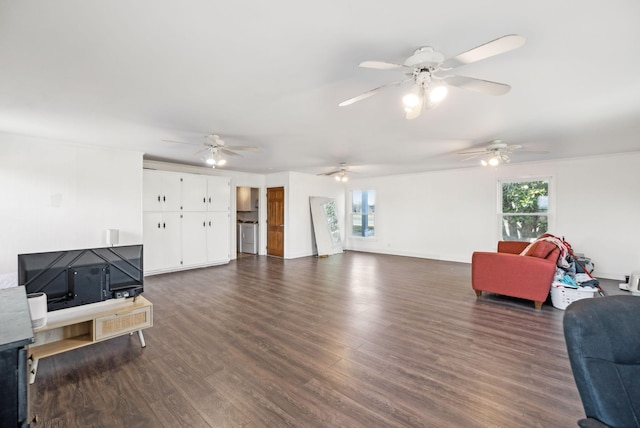 living area featuring baseboards, dark wood finished floors, and washer / clothes dryer