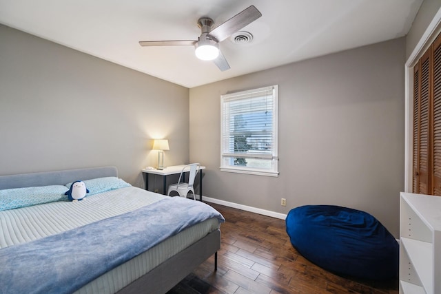 bedroom with visible vents, wood finished floors, a closet, baseboards, and ceiling fan