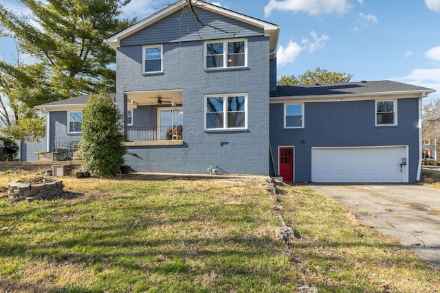 view of front of home with a front yard, a ceiling fan, driveway, a garage, and brick siding