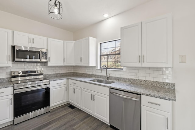 kitchen featuring white cabinets, backsplash, stainless steel appliances, and a sink