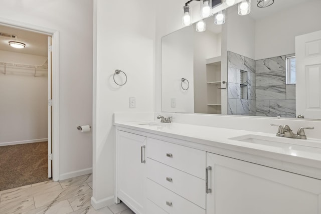 bathroom with marble finish floor, a sink, visible vents, and a walk in closet