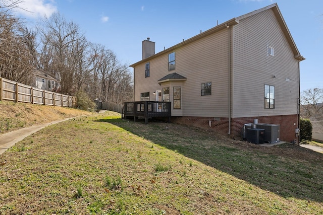 rear view of property featuring a chimney, fence, a deck, cooling unit, and a yard