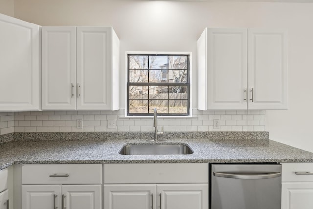 kitchen featuring dishwasher, white cabinetry, decorative backsplash, and a sink