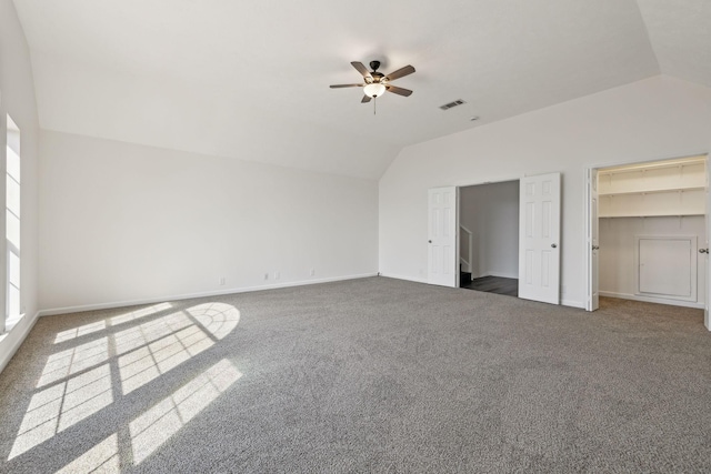 unfurnished bedroom with carpet, visible vents, vaulted ceiling, ceiling fan, and baseboards