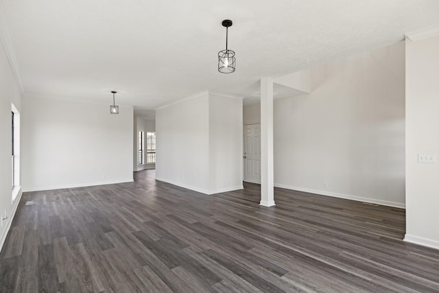 unfurnished room featuring crown molding, dark wood finished floors, and baseboards