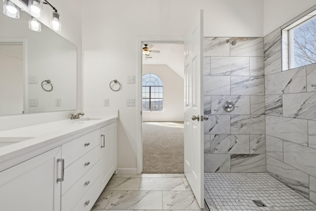 full bath with double vanity, marble finish floor, a sink, and tiled shower