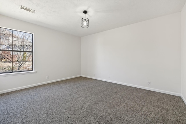 unfurnished room with dark colored carpet, visible vents, and baseboards